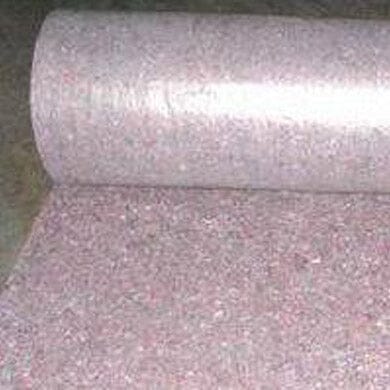 A roll of pinkish fiber matting material partially unrolled on a flat surface, often used for insulation or cushioning purposes.