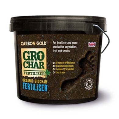 A black tub of Carbon Gold GroChar Organic Biochar Fertiliser with a handprint in soil, product details, and a UK flag on the label.